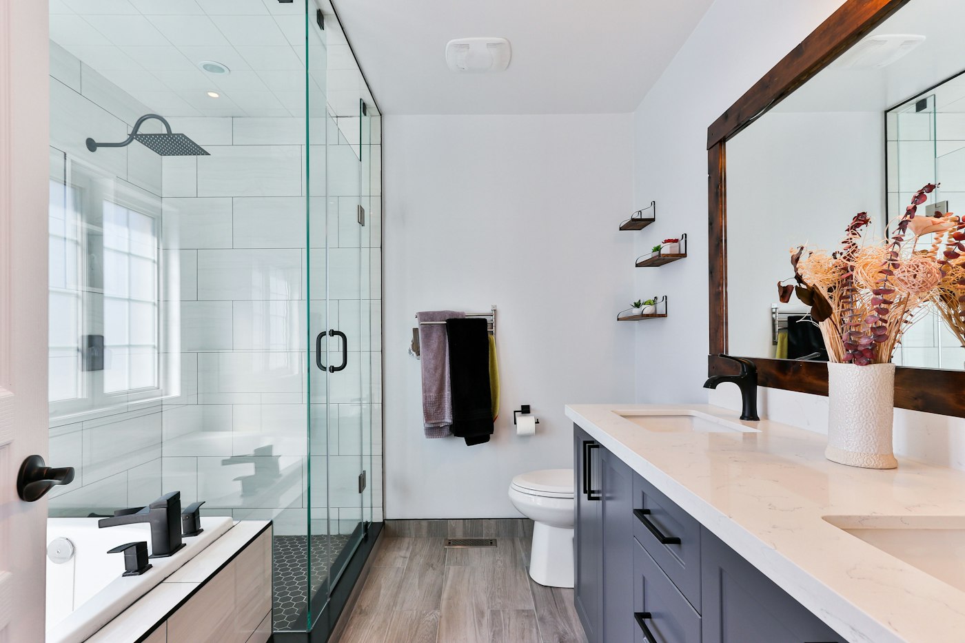 Bright modern bathroom with a glass shower, vanity and toilet